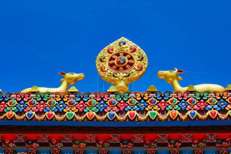 Twin deers symbolizing the skillful means and wisdom principles of Buddhist belief along with the Dhamma chakra on top of Tengboche Monastery in Nepal