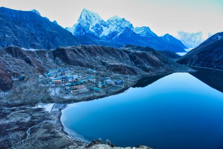 Téléchargez les photos : La feuille de verre comme surface calme du lac de Gokyo avec le village de Gokyo et les sommets himalayens de Cholatse, Taboche et Kangtega présentent un portrait comme scène himalayenne - en image libre de droit