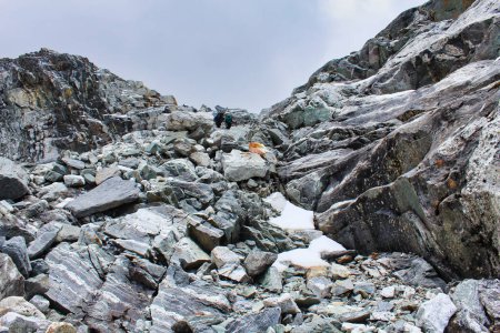 Trekker beginnen den anspruchsvollen Aufstieg über riesige Felsbrocken über den berühmten Cho La Pass in 5400 Metern Höhe, der die Täler Gokyo und Khumbu in Nepal verbindet