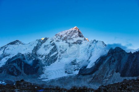 Cumbres de Nuptse y Everest iluminadas por los últimos rayos del sol poniente en esta tranquila escena crepuscular de Gorakshep en Nepal