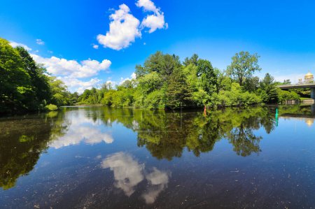 Brilliant azure blue skies with clouds over the sparkling Rideau river on a bright summer day in Ottawa,Ontario,Canada