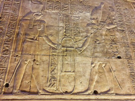 Téléchargez les photos : Mur bas relief de Pharoah Ptolémée faire des offrandes à Horus dans le temple d'Horus à Edfou construit au cours de l'ère ptolémaïque entre 237 à 57 avant JC près d'Assouan, Egypte - en image libre de droit