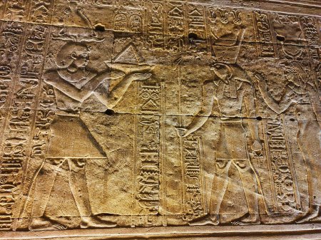 Téléchargez les photos : Mur bas relief de Pharoah Ptolémée faire des offrandes à Horus et Hathor dans le temple d'Horus à Edfou construit pendant l'ère ptolémaïque entre 237 à 57 avant JC près d'Assouan, Egypte - en image libre de droit