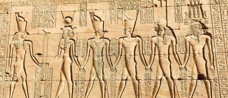 Téléchargez les photos : Majestueux relief mural de Ptolémée IV Philopator sous deux formes étant dirigé par Horus et Hathor dans le temple d'Horus à Edfou construit au cours de l'ère ptolémaïque entre 237 à 57 avant JC près d'Assouan, Egypte - en image libre de droit