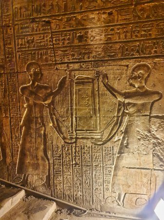 Téléchargez les photos : Prêtres portant la barque sacrée d'Horus, le Dieu Faucon représenté dans un bas-relief dans le Temple d'Horus à Edfou construit au cours de l'ère ptolémaïque entre 237 à 57 avant JC près d'Assouan, Egypte - en image libre de droit