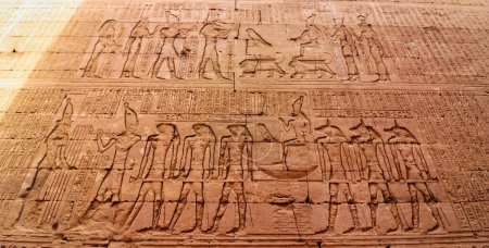 Téléchargez les photos : Mur art bas-relief de Ptolémée IX Soter II menant la procession d'Horus dans la barque sacrée dans le temple d'Horus à Edfou construit au cours de l'ère ptolémaïque entre 237 à 57 avant JC près d'Assouan, Egypte - en image libre de droit