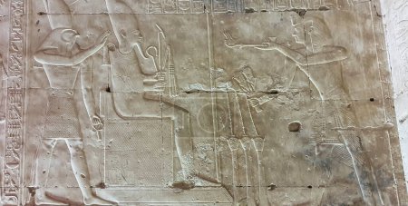 Photo for Pharoah Seti I makes offerings to Osiris seated and Horus in a wall relief in the Temple of Seti built in 13th century BC by the Pharoah Seti I near Abydos,Egypt - Royalty Free Image