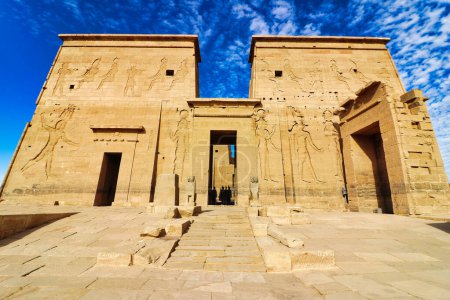 Los pilones imponentes con relieves de pared que representan a Ptolomeo, Isis y Horus contra un cielo azul brillante en el Templo de Isis en la isla de Philae en el lago Nasser, construido por Nectanebo y Ptolomeo Faraones cerca de Asuán, Egipto