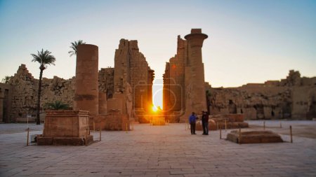 La luz del sol de la mañana llena el pasaje central del Gran Templo de Karnak con vistas de enfoque suave de los pilones de entrada en el complejo del templo de Karnak dedicado a Amón-Ra en Luxor, Egipto