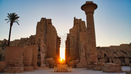 La luz del sol de la mañana llena el pasaje central del Gran Templo de Karnak con vistas de enfoque suave de los pilones de entrada en el complejo del templo de Karnak dedicado a Amón-Ra en Luxor, Egipto