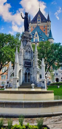 View of Place D Armes and the Gothic fountain with the Faith Monument commemorating the three-hundred year anniversary of the arrival of the Recollet Fathers in Quebec in Quebec city, Canada