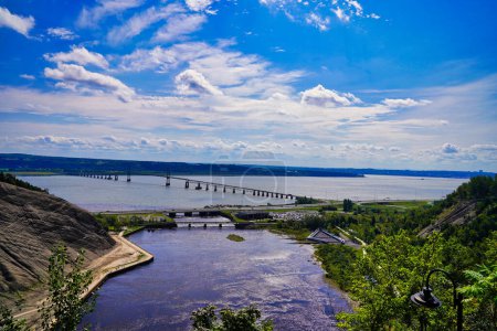 Spectacular vista of the St.Lawrence river, the Pont de Ille bridge on a bright summer day taken from the top of the 83m high Montmorency Waterfalls near Quebec city,Canada