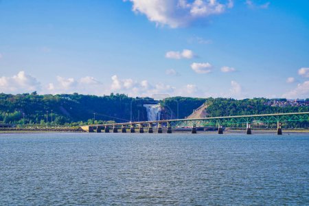 Panoramic view of the Pont de l'lle bridge with the Montmorency falls in the background taken from cruise boat on a bright summer day on the St.Lawrence river near Quebec city, Canada