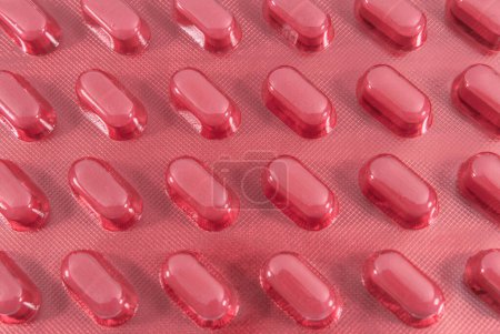 Téléchargez les photos : Pilules médicales emballées dans une plaquette rouge. Médicaments et soins de santé - en image libre de droit
