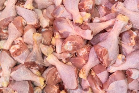 Photo for Uncooked chicken legs, drumsticks on a market counter. Meat products - Royalty Free Image