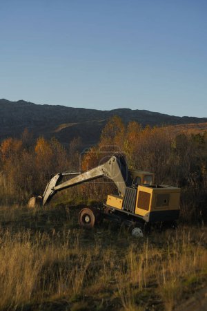 Photo for Abandoned heavy machinery excavator in the landscape during peak autumn, industrial waste in the arctic regions - Royalty Free Image