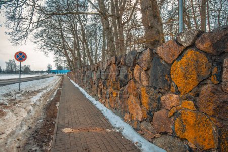 Foto de Albañilería de pared de piedra, pared de casa. Brujas carretera invierno. Sendero peatonal. - Imagen libre de derechos