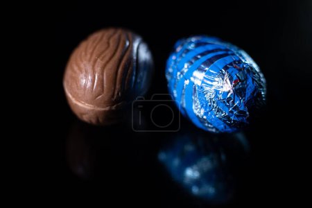 Foto de Huevos de Pascua sobre fondo negro. Fondo colorido huevos de Pascua. Un huevo de chocolate. - Imagen libre de derechos
