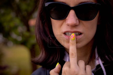 Foto de El dedo de una mujer es puesto en sus labios como una señal de no hablar. Enfoque selectivo suave. - Imagen libre de derechos