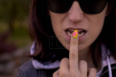 Photo for A woman's finger is put to her lips as a sign of not speaking. Soft selective focus. - Royalty Free Image