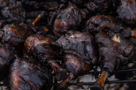 Photo for Charcoal grilled chicken drumsticks marinated in blueberries. Soft selective focus. - Royalty Free Image