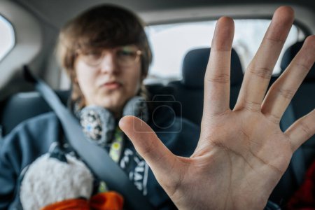 Foto de El pasajero del coche, un joven, se sienta en la parte trasera y conduce al aeropuerto con el cinturón de seguridad abrochado" - Imagen libre de derechos