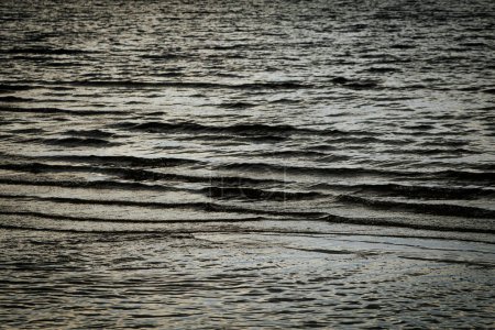 Dark ominous sea water with waves. Soft selective focus. Artificially created grain for the picture