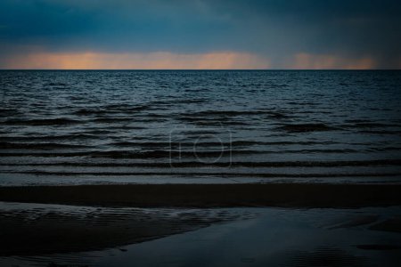 Steine am Meeresufer mit Sonnenuntergang. Weiche selektive Fokussierung. Künstlich erzeugtes Korn für das Bild