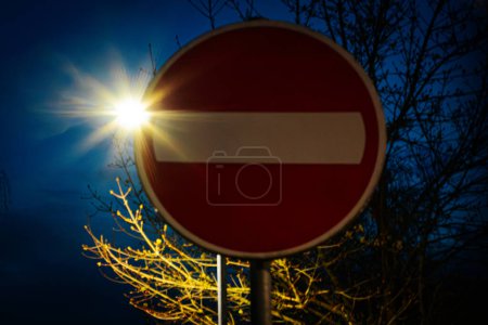 Verkehrszeichen Fahrverbot und Sonne am Abend. Weiche selektive Fokussierung. Künstlich erzeugtes Korn für das Bild