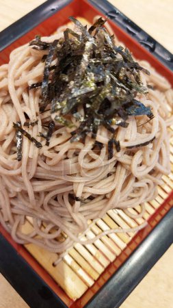 Japanese chilled noodle and seaweed served over bamboo strainer.