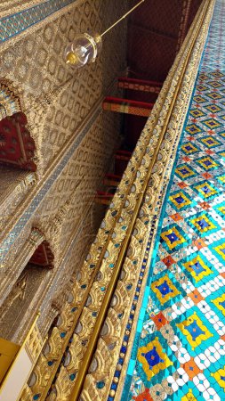 The Temple of Emerald Buddha is built from a wooden frame that adorned by rich ceramic tiles, mural paintings, gold leaf ornamentation and other important Thai mythological and religious symbolism.