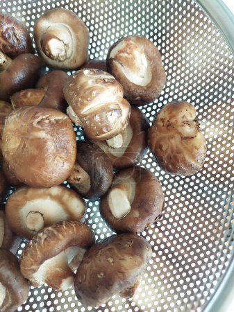 Téléchargez les photos : Champignons Shitake frais dans un panier en acier inoxydable. - en image libre de droit