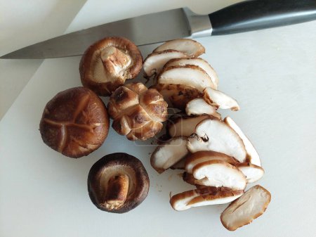 Préparation de champignons Shitake fraîchement pelés pour la cuisson à la maison.