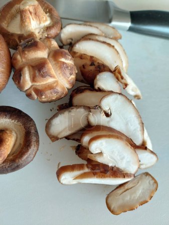 Téléchargez les photos : Préparation de champignons Shitake fraîchement pelés pour la cuisson à la maison. - en image libre de droit
