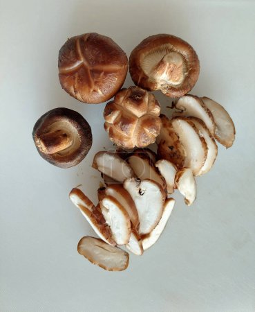 Téléchargez les photos : Préparation de champignons Shitake fraîchement pelés pour la cuisson à la maison. - en image libre de droit