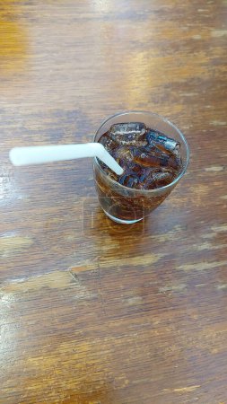 Cool Cola Served Over Ice on Wooden Table, Restaurant in Bangkok.