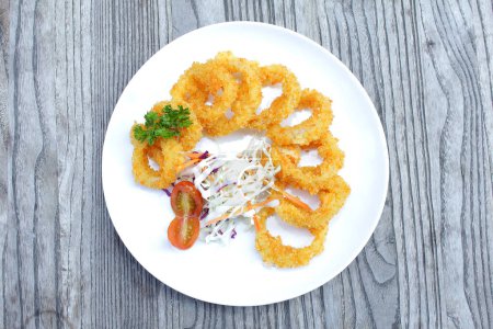 Photo for Delicious fried food, fried squid rings breaded with a slice of tomato - Royalty Free Image