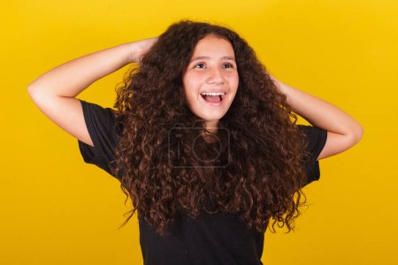 Photo for Brazilian, Latin American girl, for afro hair, yellow background, hands on her head, hair symbol, curly hair, curls, coiffed hair, beautiful hair, hair products - Royalty Free Image
