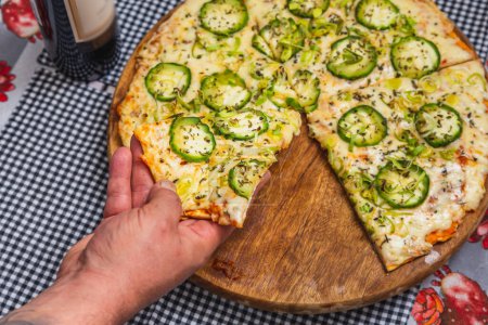 Photo for Delicious vegetarian cucumber pizza being eaten using hand, fast food, brazilian pizza. - Royalty Free Image