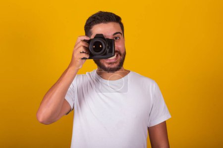 Photo for Brazilian latin american man, happy, holding digital camera, concept of photography, photographer, profession, hobby, pastime. - Royalty Free Image