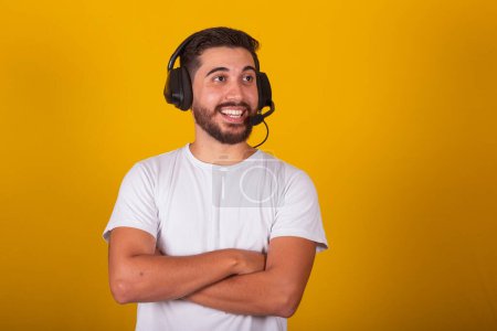 Foto de Hombre latinoamericano brasileño feliz con auriculares y micrófono, telemarketer, soporte telefónico, soporte telefónico, concepto de telemarketing. - Imagen libre de derechos