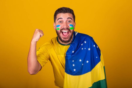 Photo for Brazilian man, latin american, cheering for brazil, 2022 world cup, patriot, nationalist, screaming goal, vibrating with emotion, expression of happiness and amazement, partying - Royalty Free Image