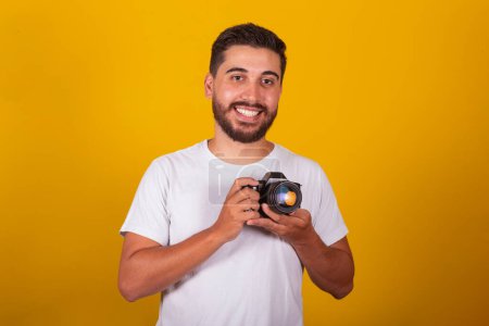 Téléchargez les photos : Brésilien latino-américain, heureux, tenant un appareil photo numérique, concept de photographie, photographe, profession, passe-temps, passe-temps. - en image libre de droit