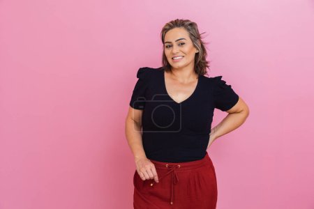 Photo for Brazilian woman, entrepreneur, aesthetic professional, with hands on her hips, pink background. - Royalty Free Image