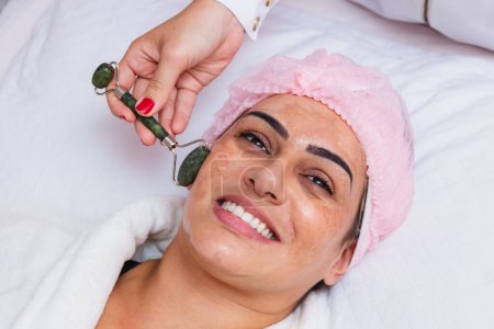 Photo for Facial massage on patient skin, using tool called jade stone, skin care - Royalty Free Image