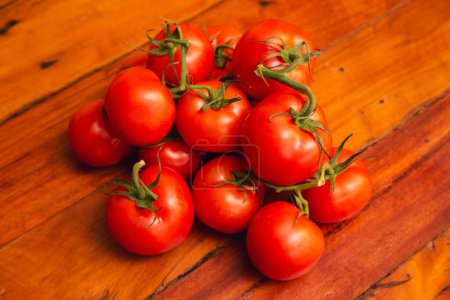 Photo for Heap of tomatoes on wooden table, composition in the center - Royalty Free Image