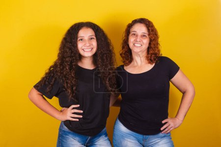 Photo for Grandmother and niece, Brazilian, Latin American, curls, afro hair, curly, smiling, hands on hips, family photo, beautiful. Mother's Day, Fraternity, Love. - Royalty Free Image