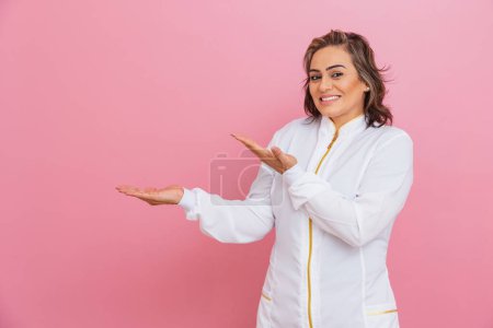 Photo for Professional beautician, entrepreneur woman, aesthetic doctor, pointing to the left side, negative space, advertisement, advertisement. - Royalty Free Image