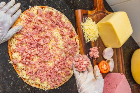 Foto de Mezcla de jamón y queso mozzarella pizza que se prepara, pre-horneado, pizza en casa. - Imagen libre de derechos