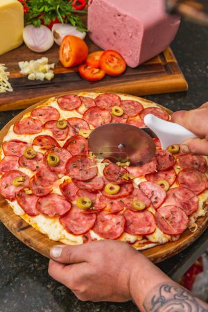 Foto de Deliciosa pizza de pepperoni en rodajas, pizza al horno, pizza de pepperoni con aceitunas. Pizza brasileña - Imagen libre de derechos